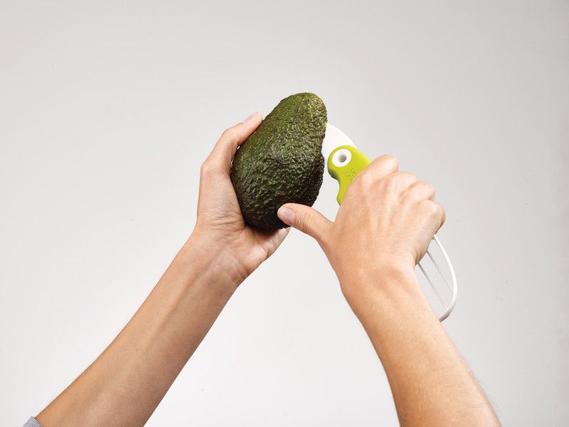 Avocado preparation tool featuring a fold-out blade, stainless-steel pitter, and ergonomic handle for easy use.