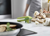 Joseph Joseph Cleanforce Garlic Press with built-in wiper for easy crushing and cleanup, enhancing kitchen efficiency.