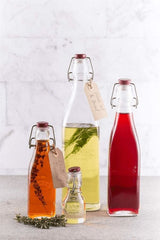 Clear glass Kilner Clip Top Bottle 1 Litre for stylish food storage, featuring a secure grey lid and bold embossing.