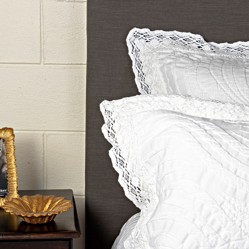 Elegant Secchi Pillowsham with crochet lace border, crafted in Portugal, blending cotton, viscose, and silk for luxurious bedding.