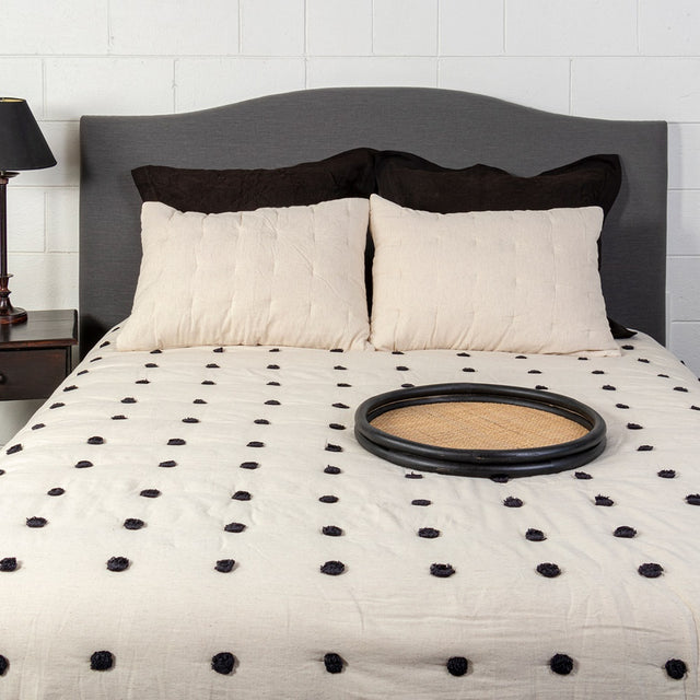 Luxurious Astrid Queen Quilt in black with playful pom poms, perfect for stylish comfort on queen-sized beds.