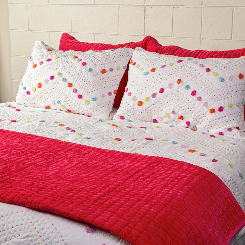 Hand quilted Madelyn King Single Quilt in vibrant colors with pom poms, perfect for cozy nights in a young girl's room.