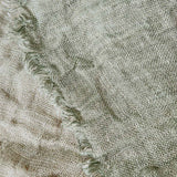 Luxurious reversible linen throw in two-tone design with distressed eyelash edge, perfect for enhancing home decor.