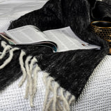 Luxurious black mohair blend throw with charming bumble fringes, perfect for cozying up or adding elegance to any space.