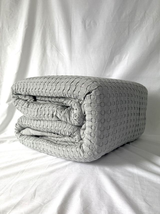 Cozy grey queen blanket with bamboo-cotton front and plush sherpa backing, featuring a stylish waffle weave.