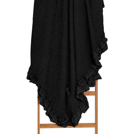 Luxurious black cotton waffle blanket with frill, perfect for year-round comfort and stylish layering.