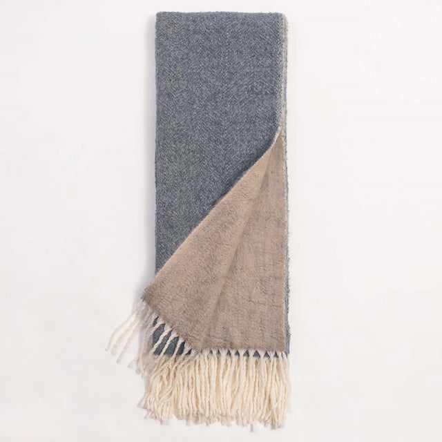 Cozy two-toned grey throw blanket (130 x 170 cm) with elegant tasseled edges, perfect for styling and warmth in any space.