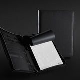 Sleek black A4 portfolio with zipper, premium Italian PU leather, notepad, phone stand, and sophisticated Swiss Peak badge.