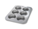 USA Pan 6-Well Mini Round Cake Pan for baking six delightful mini cakes, featuring a non-stick coating and durable aluminized steel.