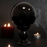 Black crystal ball on wooden stand, 130mm, perfect for home decor and mystical practices, includes beginner's guide.