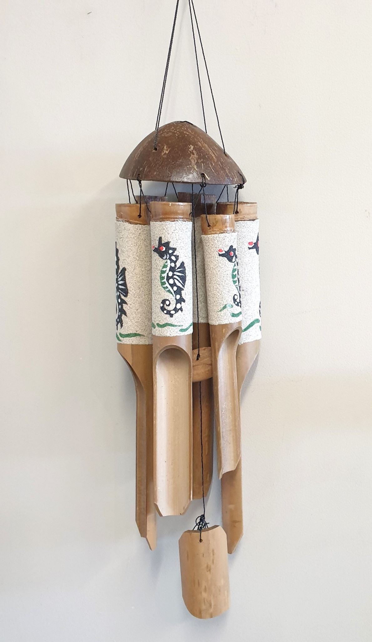 Coastal-inspired wind chimes featuring sand-painted seahorses, perfect for creating a serene outdoor ambiance.