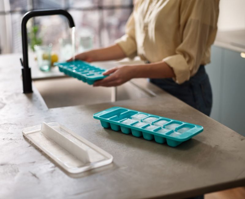 Joseph Joseph Flow Easy-fill Ice-cube Tray set with linked cavities and stackable lids, holds 14 ice cubes each without spills.