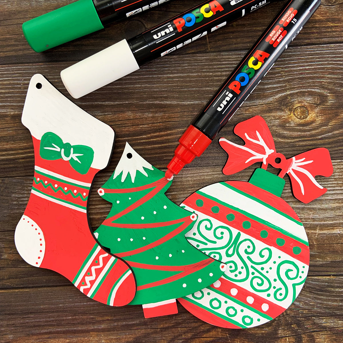 Uni Posca Marker PC-5M Christmas Decorations Activity Pack 2 with wooden ornaments and gold, silver, and bronze markers.