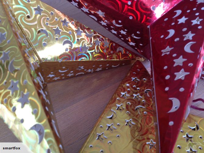 Three 45cm red star lanterns featuring intricate cut-outs that project enchanting patterns, ideal for festive decor.