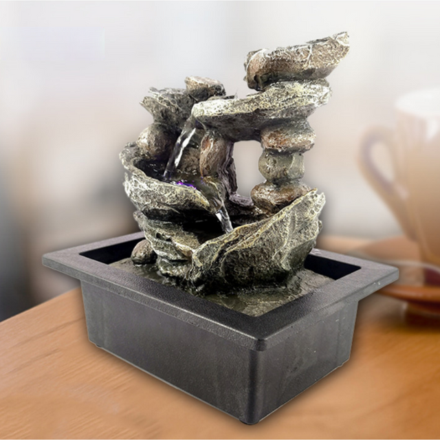 4 Tier Rocks Water Feature with cascading water flow and multicolored LED lights, perfect for enhancing indoor or outdoor spaces.