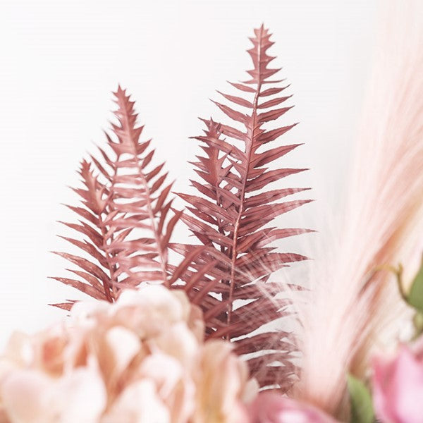 Dusty pink artificial fern spray measuring 54cmH, perfect for adding whimsy and elegance to any decor.