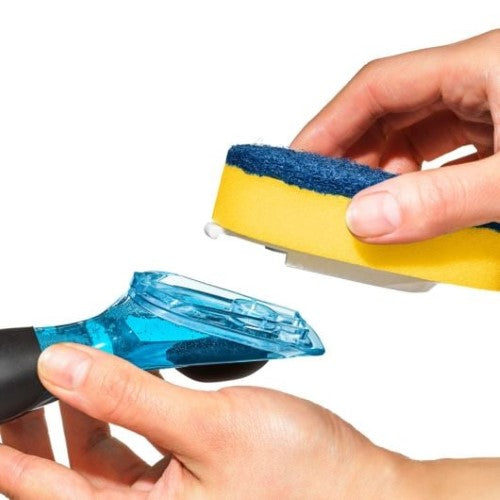 Ergonomic soap dispensing dish scrubber with a drip-free valve and built-in scraper for easy, efficient cleaning.