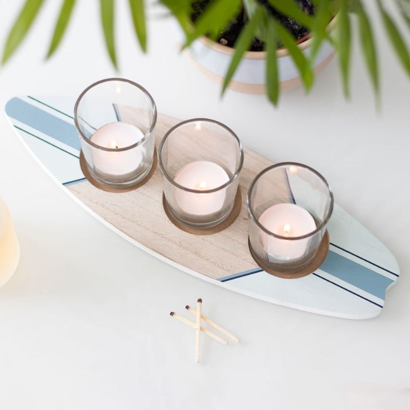 Surfboard-shaped tealight holder for 3 candles, perfect for coastal decor and beach-themed homes.