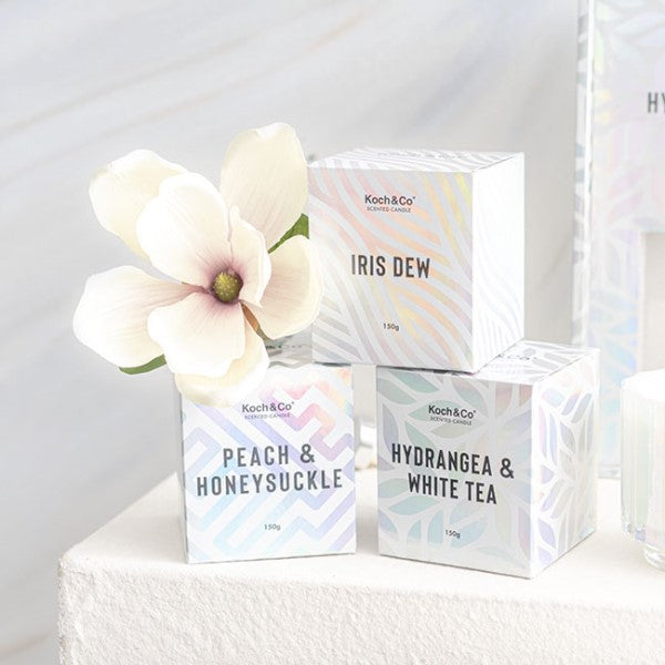 Elegant scented candle in iridescent packaging, featuring floral iris and citrus notes, burns for up to 30 hours.