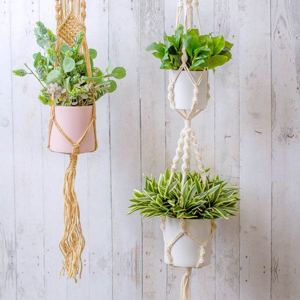Macrame pot holder in white, designed to hold two pots, enhancing indoor spaces with a bohemian charm.