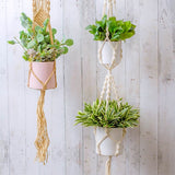 Macrame pot holder in white, designed to hold two pots, enhancing indoor spaces with a bohemian charm.