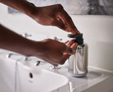 Sleek stainless steel soap pump with easy-push dispenser, 300 ml capacity, and translucent fill-level window for modern bathrooms.