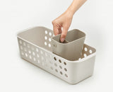 Compact bathroom storage basket with ventilated sides, customizable dividers, and moveable pot for grooming essentials.