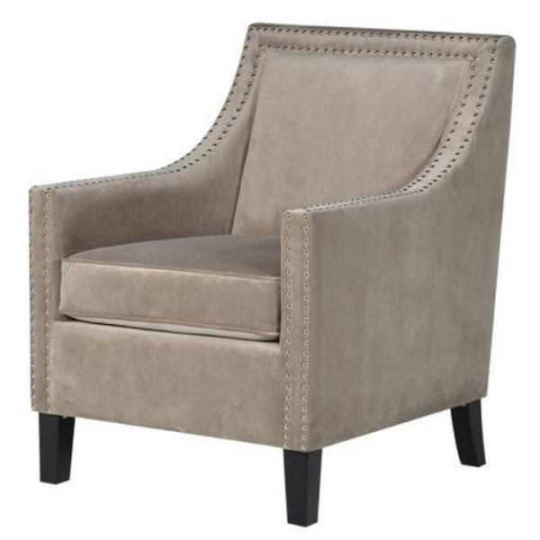 Light grey velvet Port Royal armchair with brass studs and solid timber frame, combining elegance and comfort for modern living spaces.