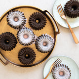 Nordic Ware Brilliance Bundtlette Pan with six 1/2 cup molds for mini Bundt cakes, made from durable nonstick cast aluminum.