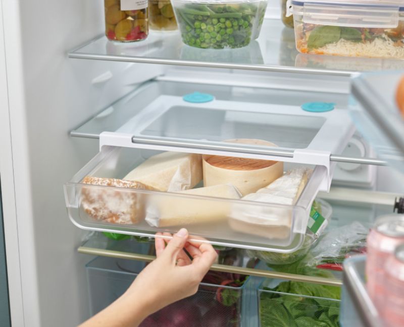 Under-shelf storage drawer designed to maximize fridge space, featuring easy-pull handle and secure suction cups for organization.