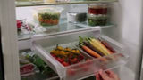 Under-shelf storage drawer for fridges, maximizing space with easy-pull handle and suction cup security.