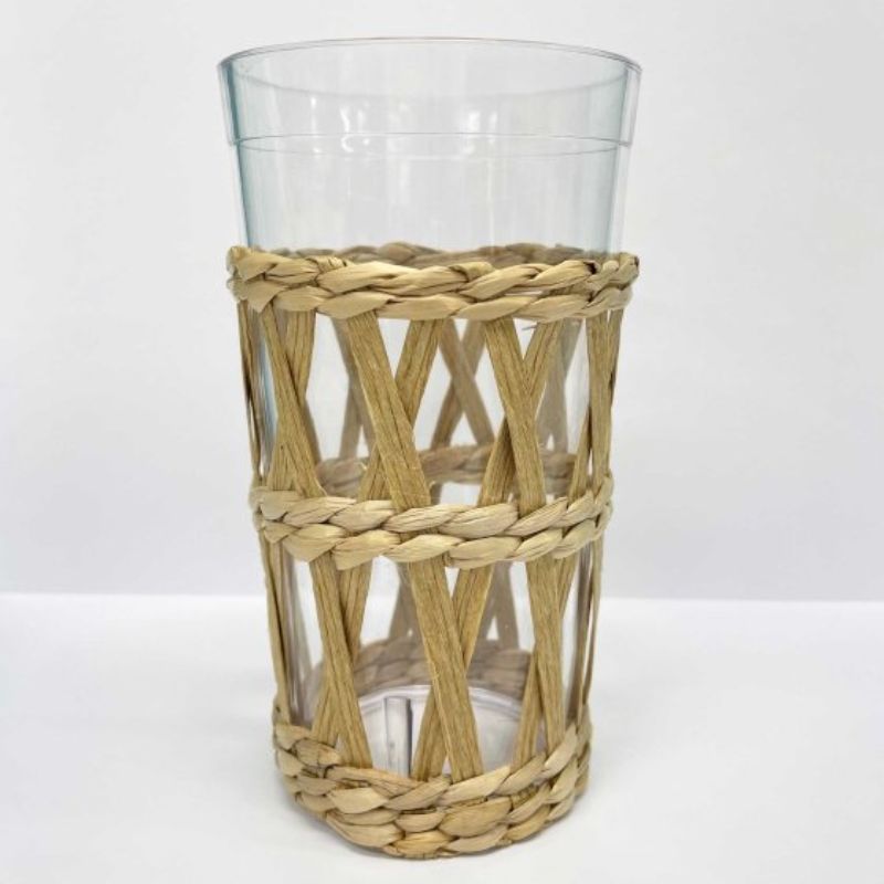 Clear plastic tumbler with a seagrass sleeve, ideal for hot and cold drinks, promoting sustainability and stylish hydration.