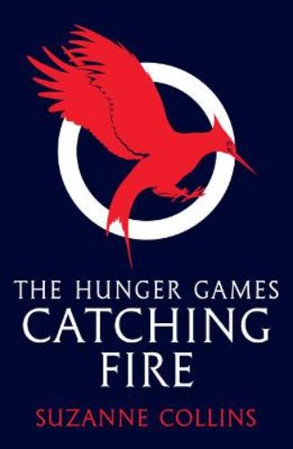 Paperback edition of 'Catching Fire' by Suzanne Collins, featuring Katniss and Peeta on a suspenseful Victory Tour.