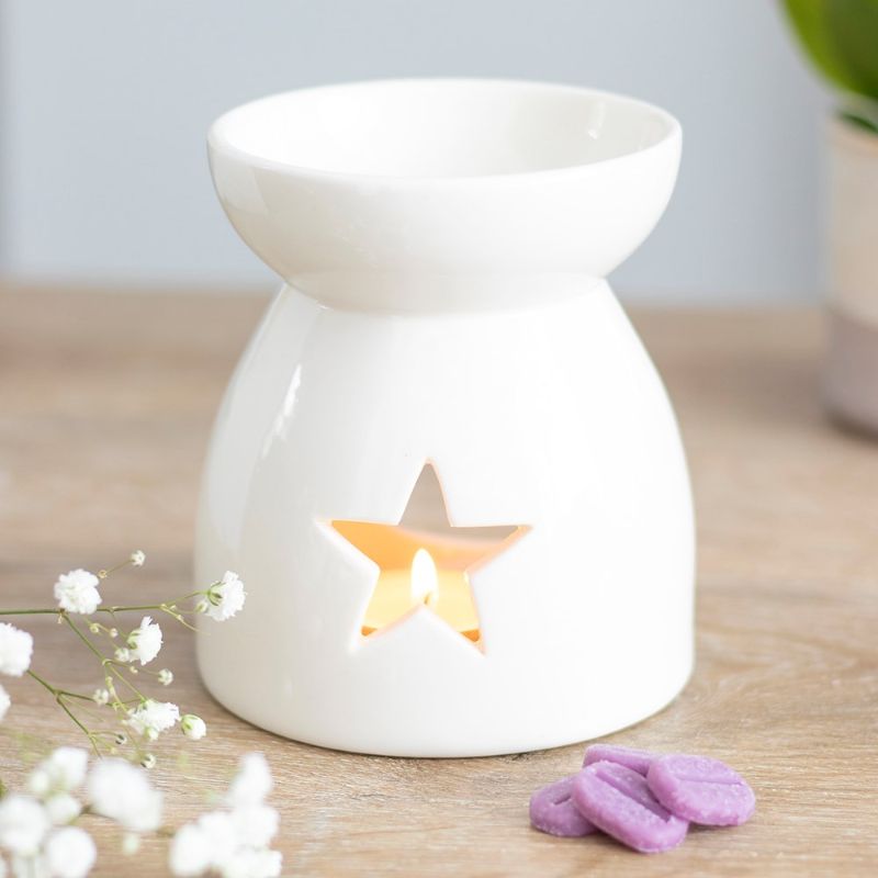 Chic white ceramic oil burner featuring star cut-outs, 11cm tall, for creating a cozy, fragrant ambiance.
