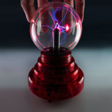 Plasma ball with red base, 3 inches, creates lightning illusions; battery-operated, sound-reactive, portable decor item.