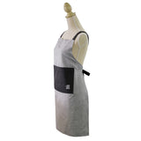 Grey chambray apron with adjustable neck strap and pockets, perfect for stylish cooking and protecting clothes.