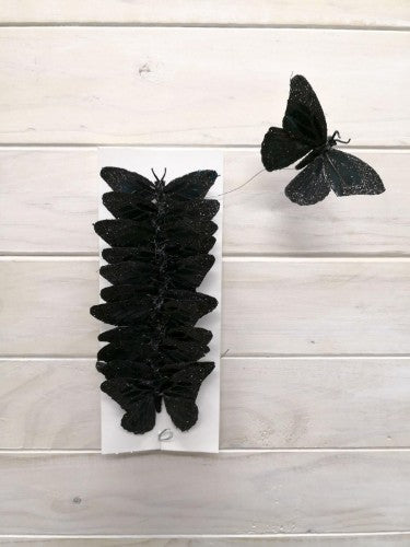 Black glitter artificial craft butterflies set of 12, featuring soft feather bodies and bendable wire for versatile decorations.