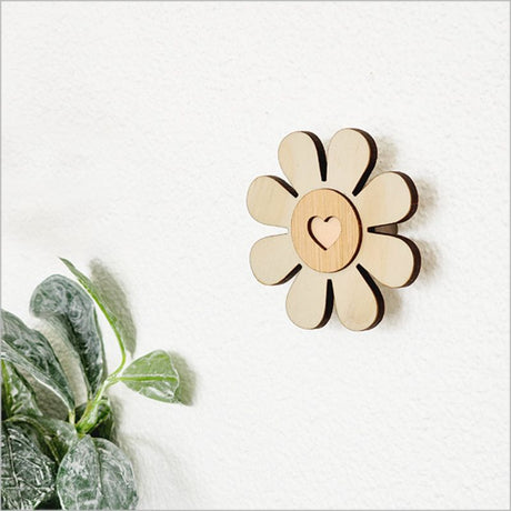 Eco-friendly 6.5cm bamboo wall hook in daisy shape, perfect for organizing baby clothes, towels, or bags.