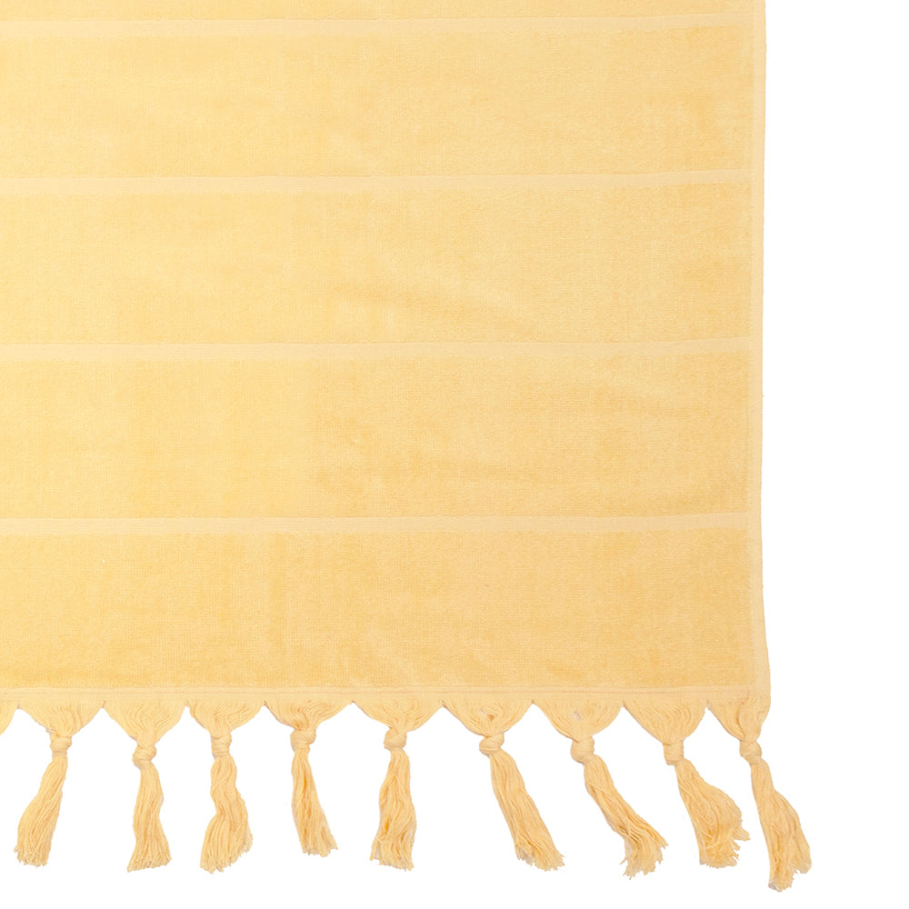 Luxurious custard beach towel with classic stripes, knotted tassels, and absorbent cotton, perfect for beach or pool outings.