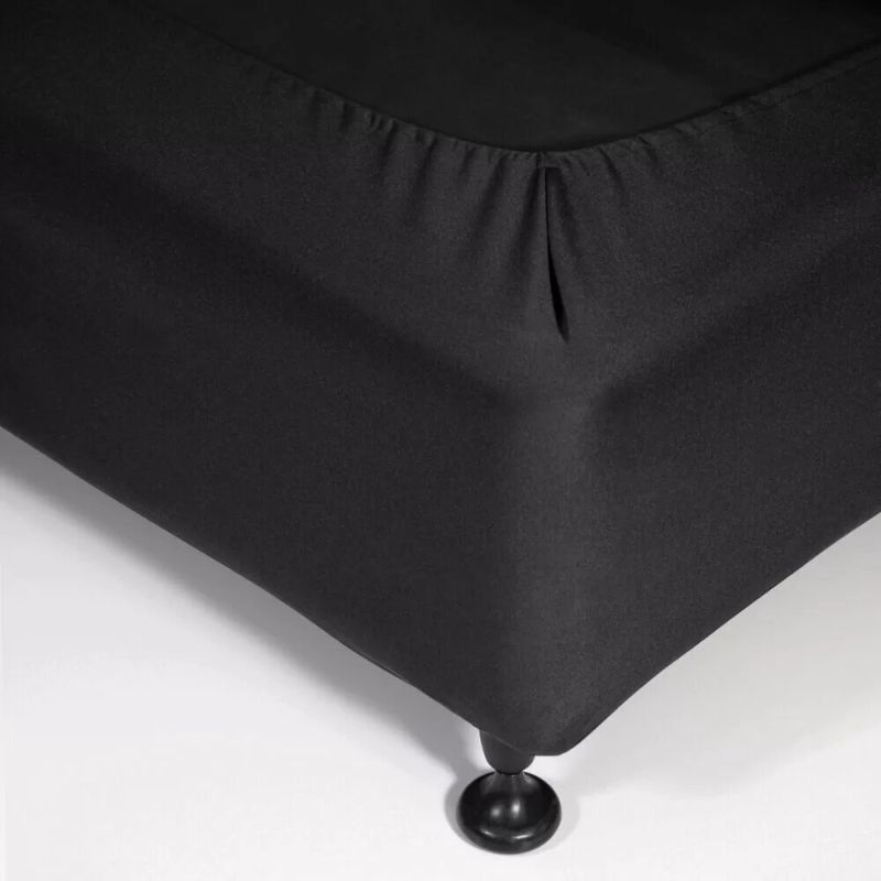 Fitted valance in sleek black, made of stretchy polyester for a snug fit and mitered corners for a polished finish.