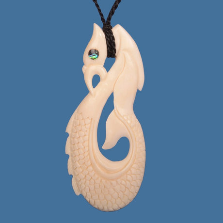 Hand-carved beef bone pendant depicting the Manaia, a M?ori guardian creature, on an adjustable black cord.