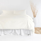 Luxurious ivory double duvet cover set in organic cotton with vintage-washed finish and stitched border for sustainable comfort.