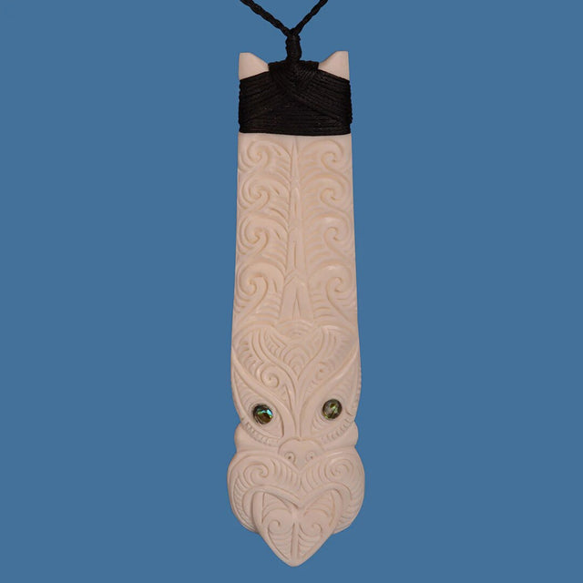 Bone Toki earrings featuring a Tiki face design with paua shell accents, handcrafted from ethically sourced beef bone.