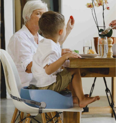 Powder blue Bumbo booster seat with 3-point harness, elevating toddlers for safe, comfortable mealtime at any table.