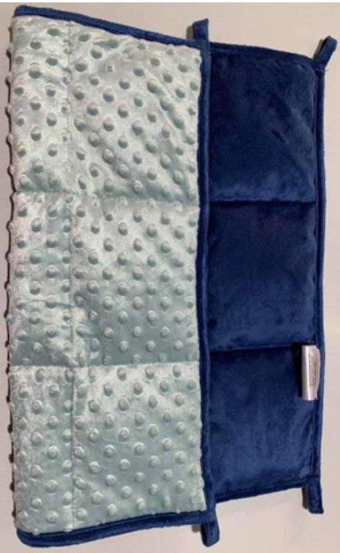 Weighted blanket lap pad in navy dot design, crafted from cotton with glass beads, promoting relaxation and reducing anxiety.