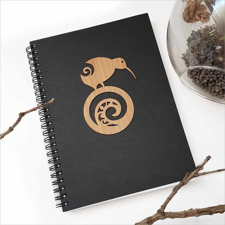 A5 black journal featuring a kiwi and koru design, perfect for capturing creative thoughts and adventures.