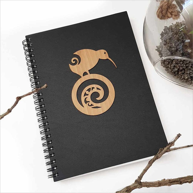 A5 black journal featuring a kiwi and koru design, perfect for capturing creative thoughts and adventures.