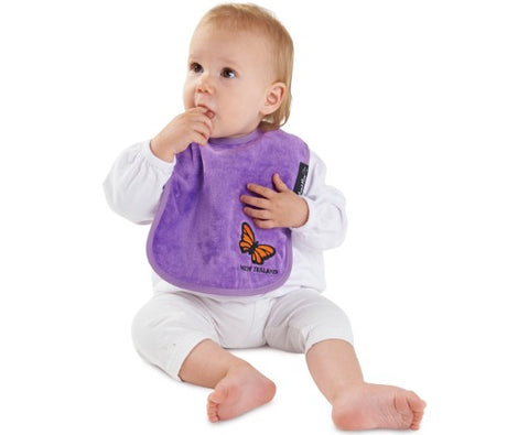 Kiwiana Wonder Bib in Purple Butterfly offers style and functionality with absorbent cotton and water-resistant backing for infants.