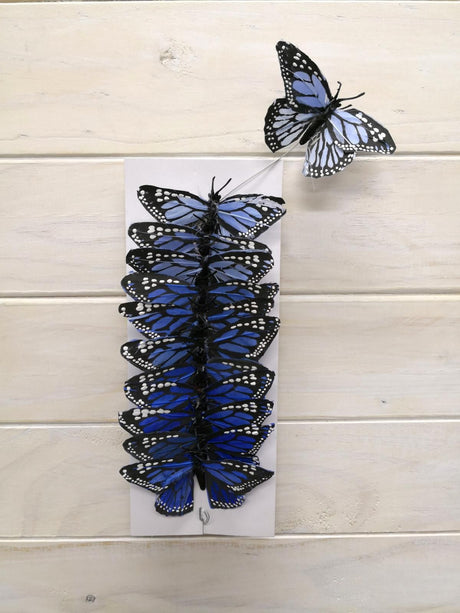 Vibrant 9cm Monarch feather butterflies in blue, perfect for home decor, weddings, and arts and crafts projects. Pack of 12.