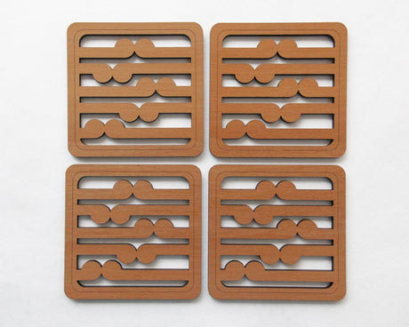 Set of four Rimu wood coasters featuring an intricate koru pattern, symbolizing growth and New Zealand craftsmanship.